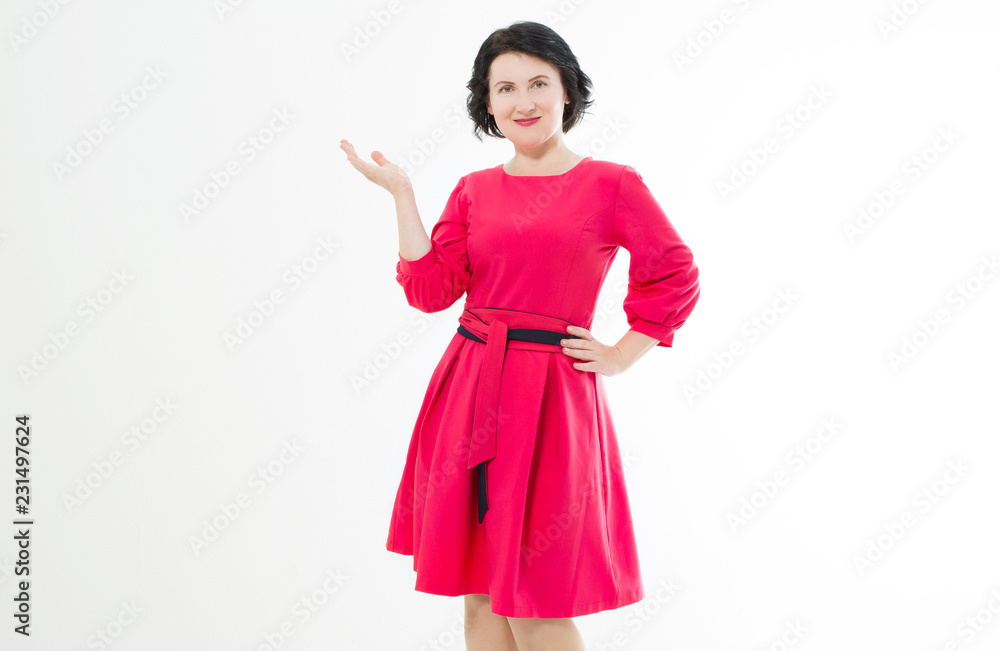 Smiling Middle age woman in red dress showing copy space by hand isolated on white background. Make up and fashion beauty concept. Copy space