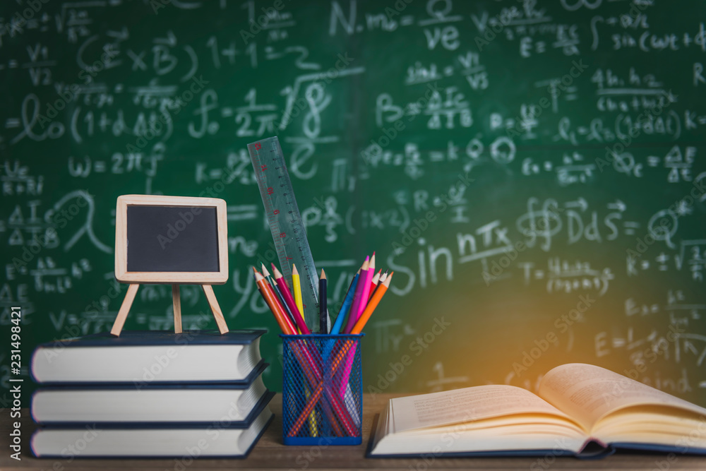 Back to school supplies. Books and blackboard on wooden background. Back to school supplies. Books and blackboard on wooden background.