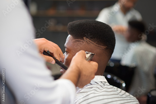 Selective focus of process of doing haircut in barber shop