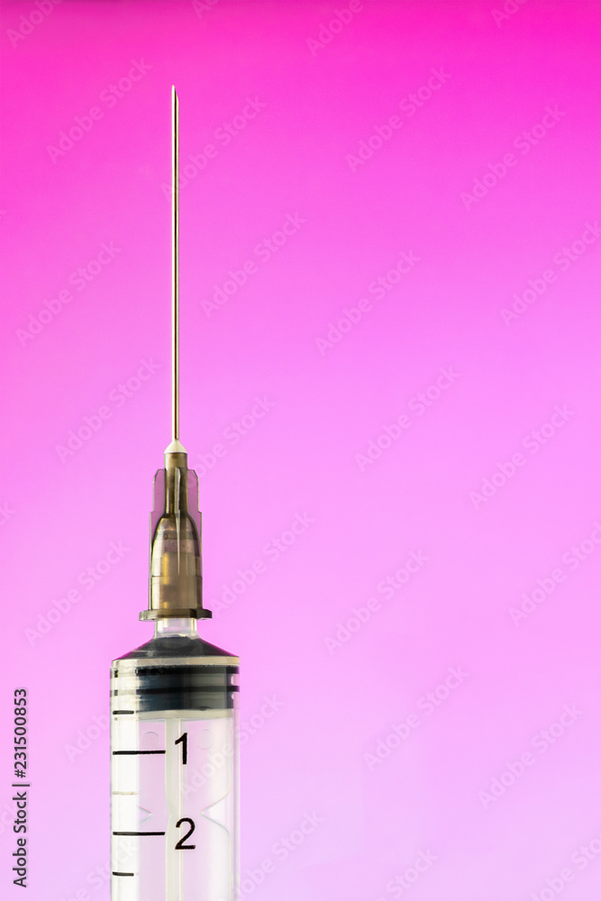 injection syringe with needle vertically close up on pink background injection syringe with needle vertically close up on pink background