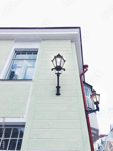 Beautiful faccade of a mint colored stone building with a glowing medieval lantern. photo