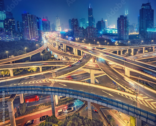 Scenic view on famous highway interchange in Shanghai, China at night. Multicolored nighttime skyline.