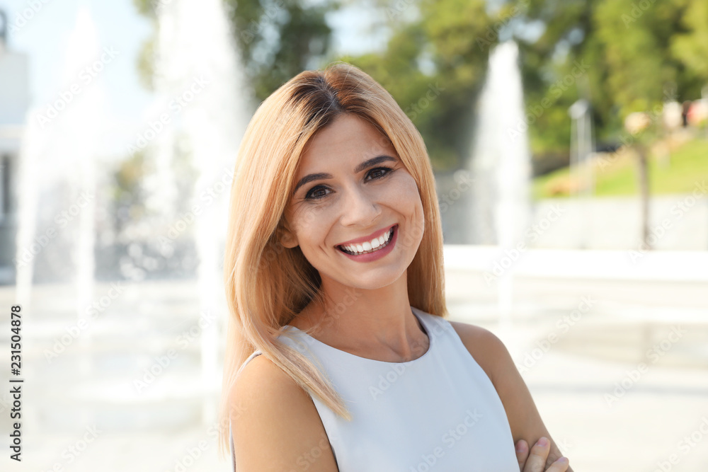 Portrait of beautiful blonde woman outdoors on sunny day