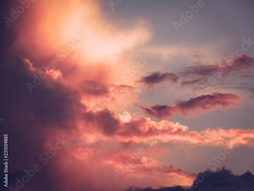 Beautiful romantic sky with pink puffy clouds during sunset.