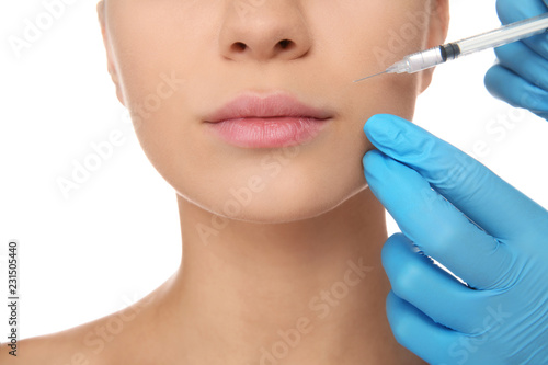 Young woman getting facial injection on white background, closeup. Cosmetic surgery concept