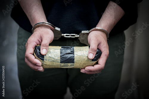 hands of a male drug dealer are handcuffed. The fight against drugs and crime.