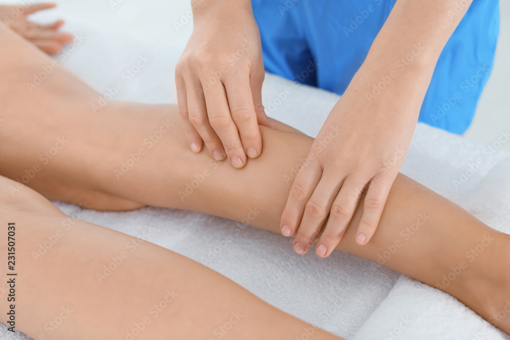 Woman receiving leg massage in wellness center, closeup Woman receiving leg massage in wellness center, closeup