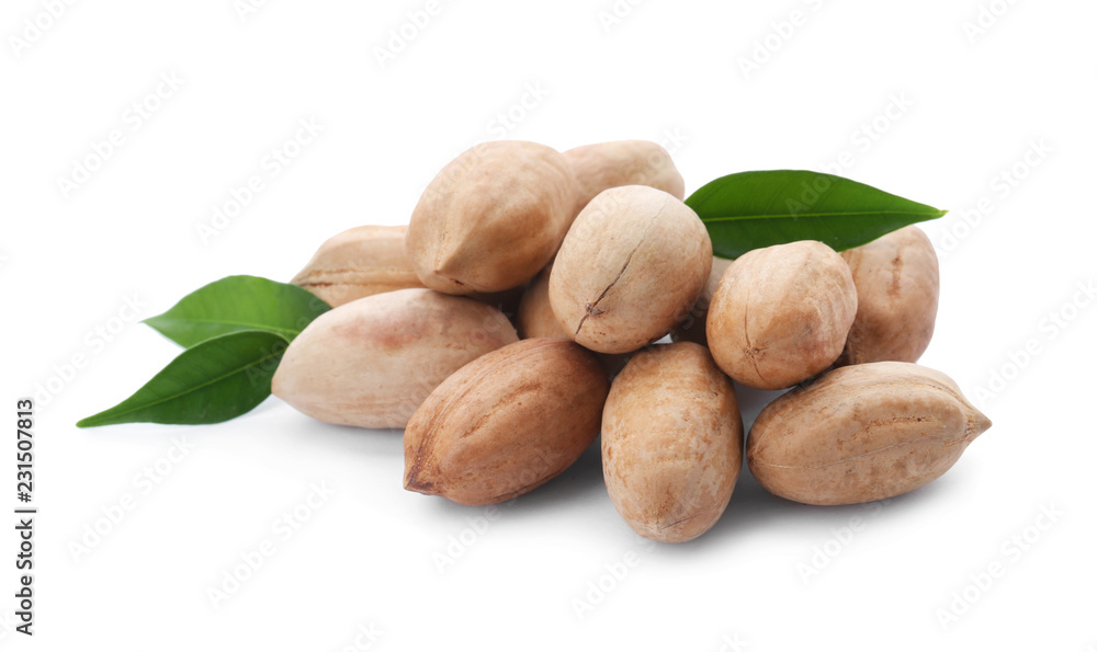 Fototapeta premium Heap of pecan nuts in shell and leaves on white background