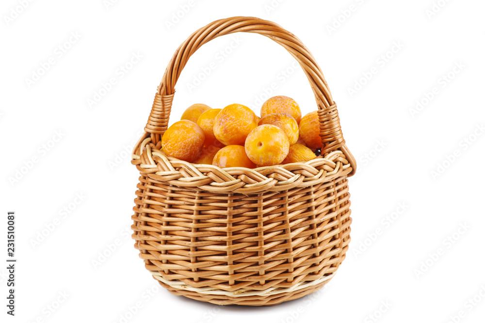 Wicker basket with half-dried yellow cherry plums isolated on the white background