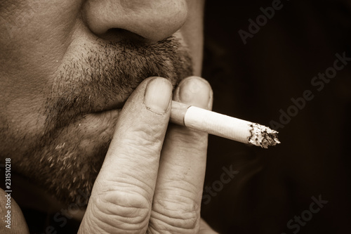 a cigarette smoking man, sepia colored photo