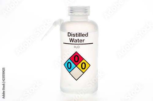 Distilled water bottle used in laboratories with name and safety code.