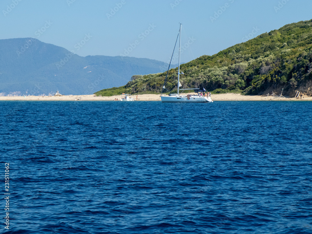 View of Tsougria Island and a yacht of the coast near a beach View of Tsougria Island and a yacht of the coast near a beach
