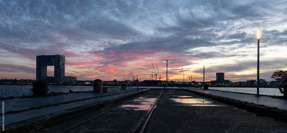 Sunset and reflections in water from a pier, Amsterdam