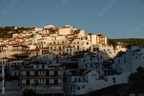 Fototapeta Naklejka Na Ścianę i Meble -  Skopelos Old Town and small greek houses on the hill as seen from the water on a sailing boat or yacht in the harbor