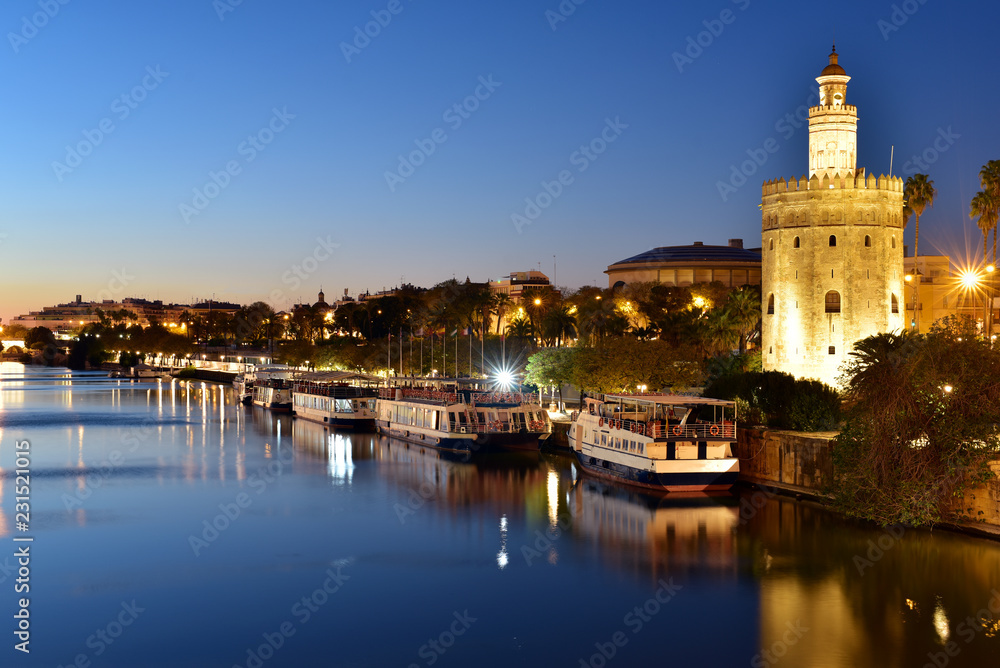 Torre del Oro (Gold Tower) illuminated at night, medieval landmark from early 13th century in Seville, Spain