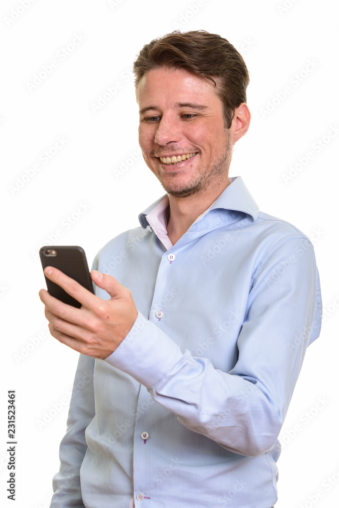 Happy Caucasian businessman smiling and holding mobile phone Happy Caucasian businessman smiling and holding mobile phone