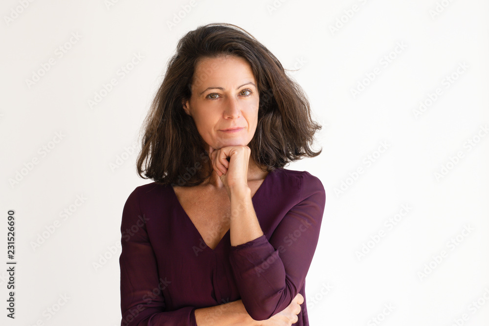 Attractive Caucasian woman holding chin. Pretty middle aged woman with pressed lips thinking about new solving problem. Business difficulties concept Attractive Caucasian woman holding chin. Pretty middle aged woman with pressed lips thinking about new solving problem. Business difficulties concept