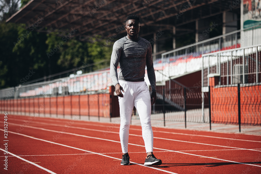 African-American sportsman and athlete training on a running track. Sweating and exhausted. Achieving goals.