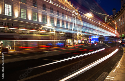 night scene of London city United Kingdom with the moving red buses and cars - long exposure photography 