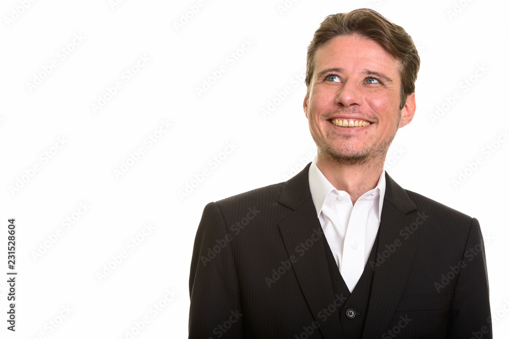 Happy Caucasian businessman thinking while smiling and looking up Happy Caucasian businessman thinking while smiling and looking up