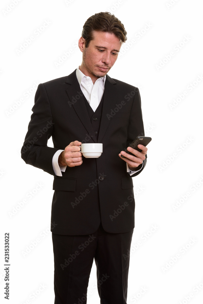 Handsome Caucasian businessman using mobile phone while holding Handsome Caucasian businessman using mobile phone while holding