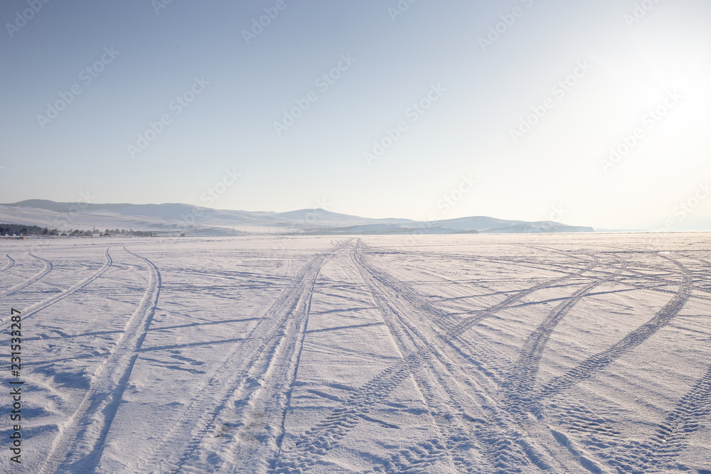 Naklejka premium Car track in fresh snow. Lake Baikal