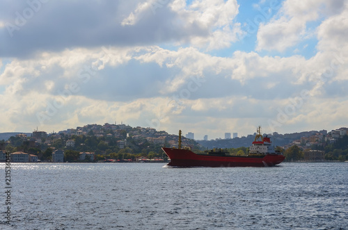 Red cargo ship goes through the Bosphorus into the Black Sea.