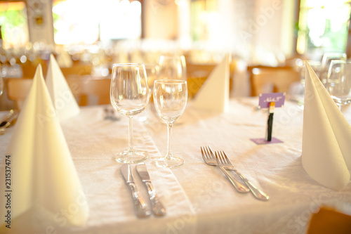 Restaurant table served with white tablecloth, wineglasses ready for guests
