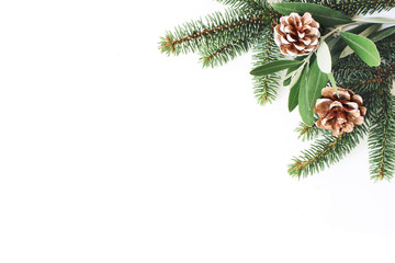 Christmas festive styled stock composition. Decorative corner. Pine cones, Fir and olive tree leaves and branches white wooden background. Flat lay, top view. Copy space.