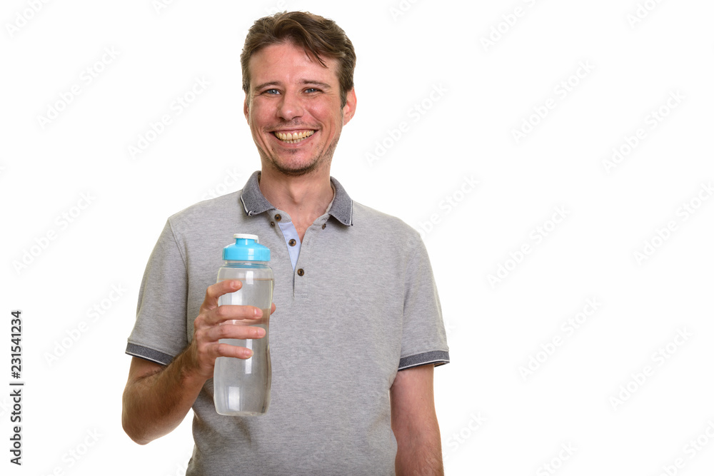Happy Caucasian man holding water bottle while smiling Happy Caucasian man holding water bottle while smiling