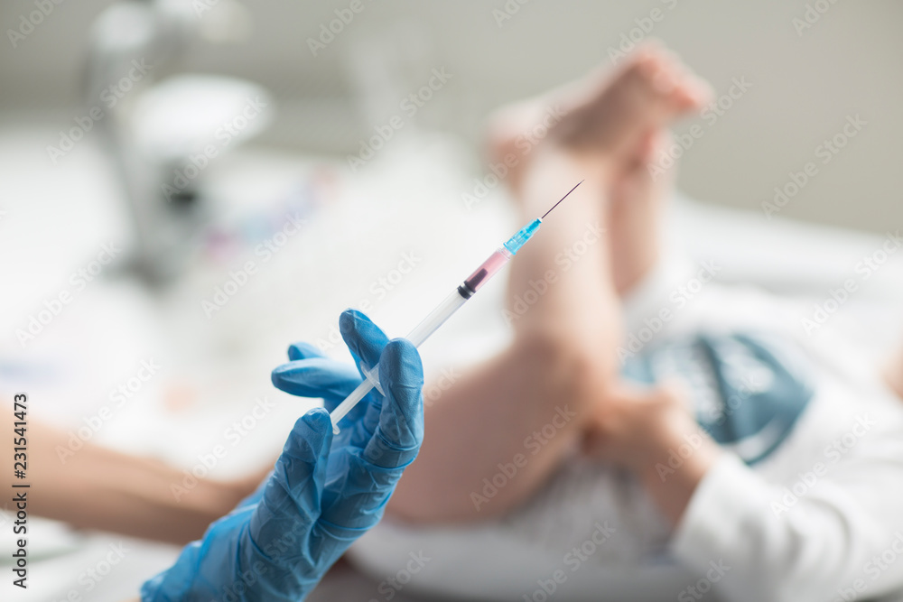 Young, female doctor giving an injection a baby boy. Young, female doctor giving an injection a baby boy.