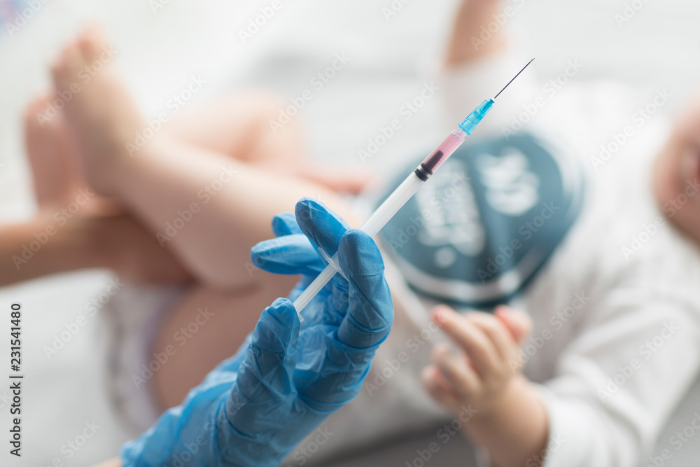Young, female doctor giving an injection a baby boy. Young, female doctor giving an injection a baby boy.