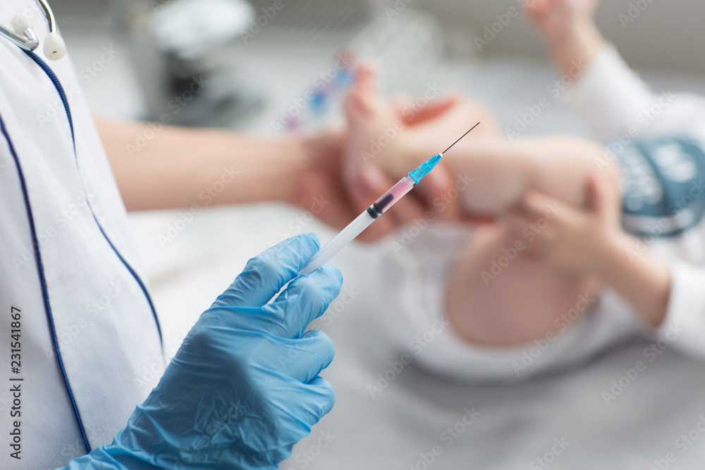 Young, female doctor giving an injection a baby boy. Young, female doctor giving an injection a baby boy.