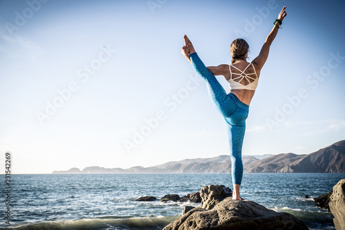 Woman making yoga poses in Baker beach, San francisco photo