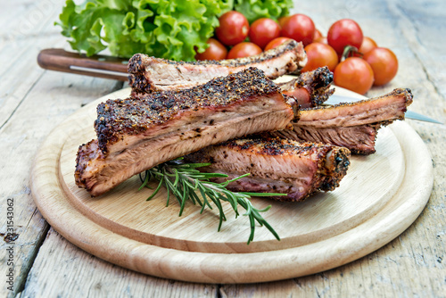 Round chopping board with grilled pork ribs photo