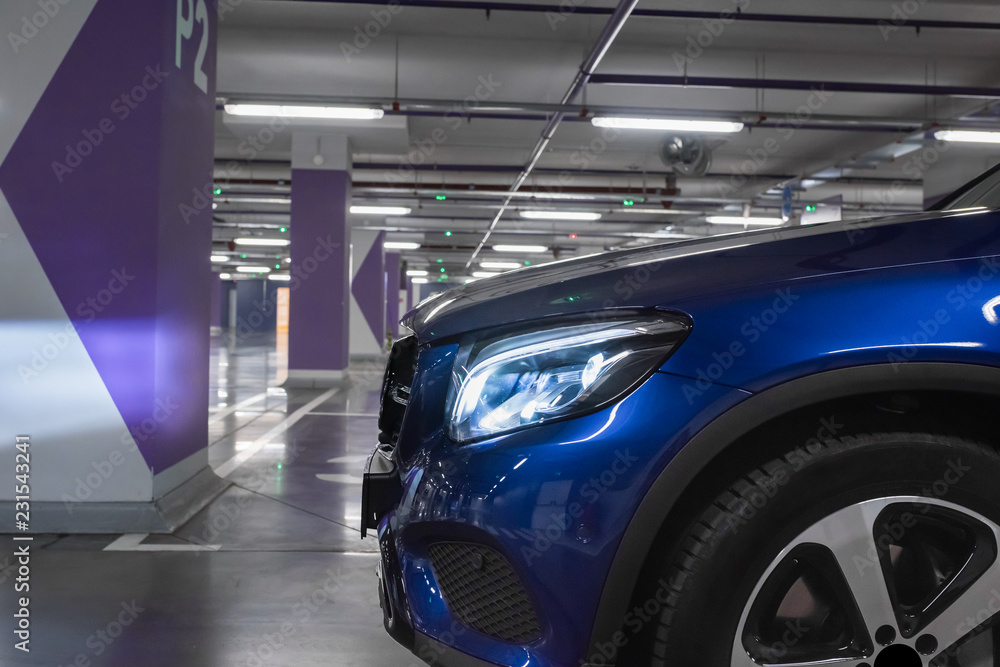 The car with the turned-on light on the underground parking The car with the turned-on light on the underground parking