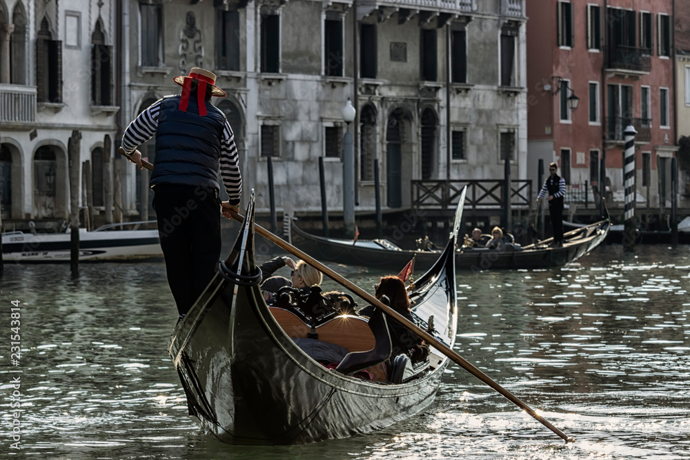 Venice, Italy - 2/21/2016. gondolier carries tourists by gondola, in canal Grande