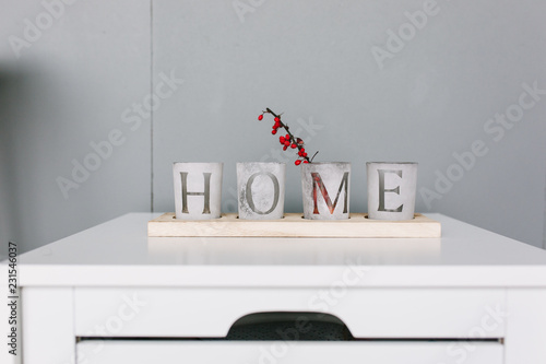 Idea of interior decoration with starfishes, word HOME on glasses standing on the top of bedrrom nightstand