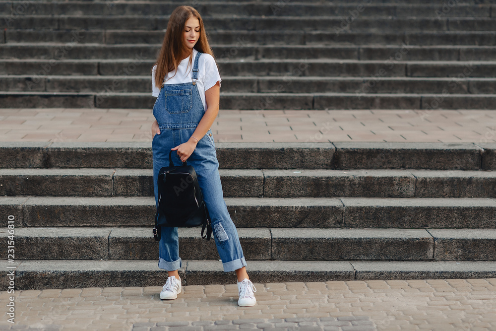 Obraz premium young pretty girl with briefcase walk on the street near building