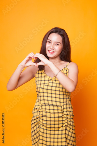 Young Asian woman show heart hand sign.
