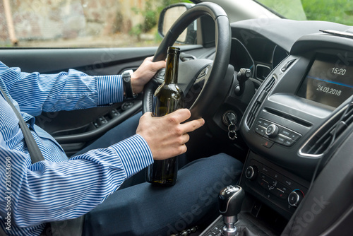 Bottle of alcohol beverage in driver hands