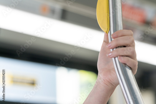 Close up of hand holding on a bar in a bus