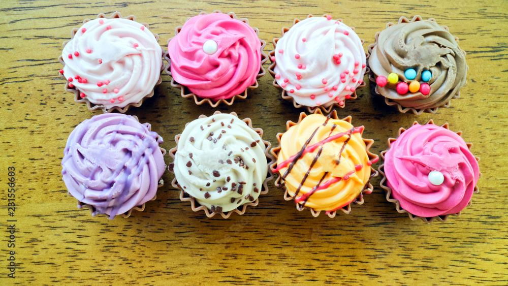 Top view of rows of colorful delicious cupcakes