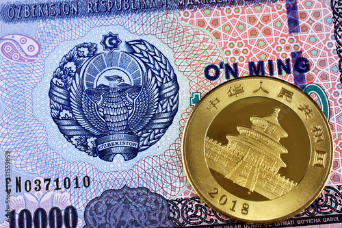 Canvas Print A macro image of an Uzbek ten thousand som bank note with a gold Chinese one oun