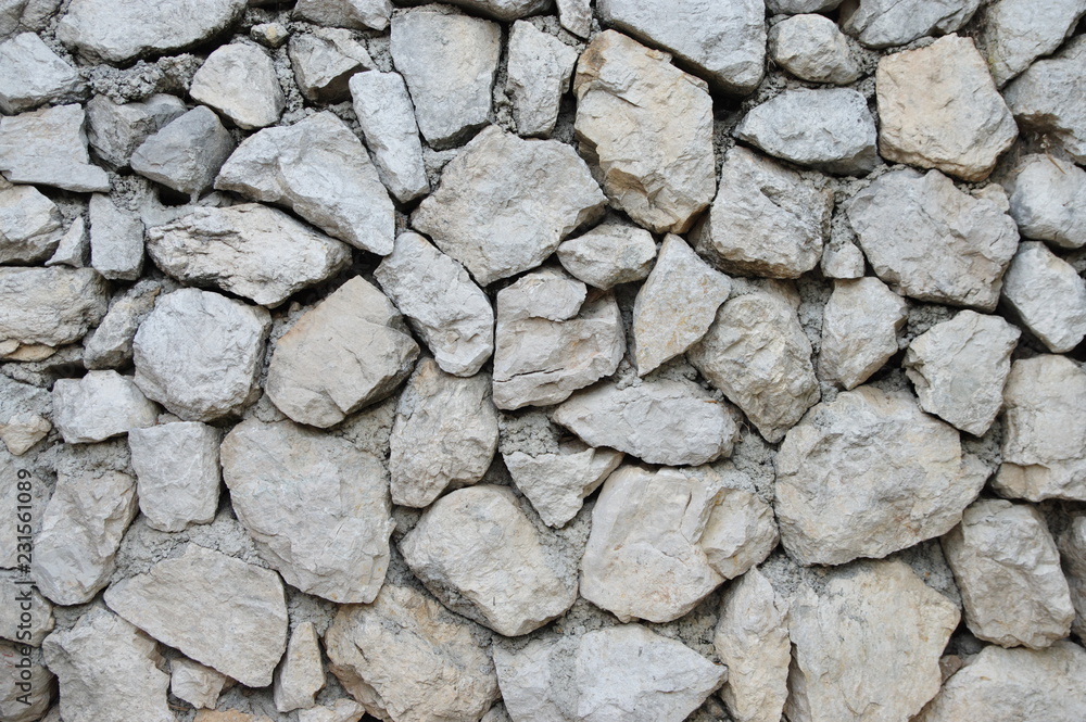 A fragment of a grey wall made of natural stones. A fragment of a grey wall made of natural stones.
