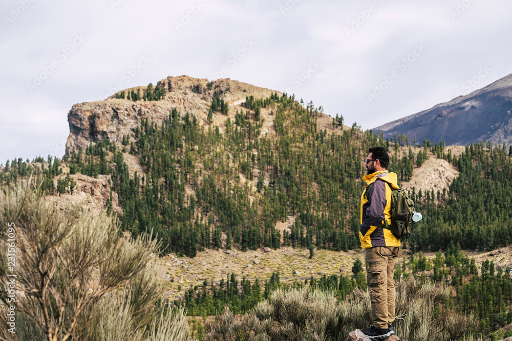 Naklejka premium Man Traveler on mountain summit with clear sky around Travel Lifestyle success concept adventure survival vacations outdoor for people love outdoors parks and scenic places. Discover nature