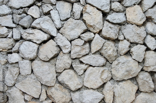 A fragment of a grey wall made of natural stones.