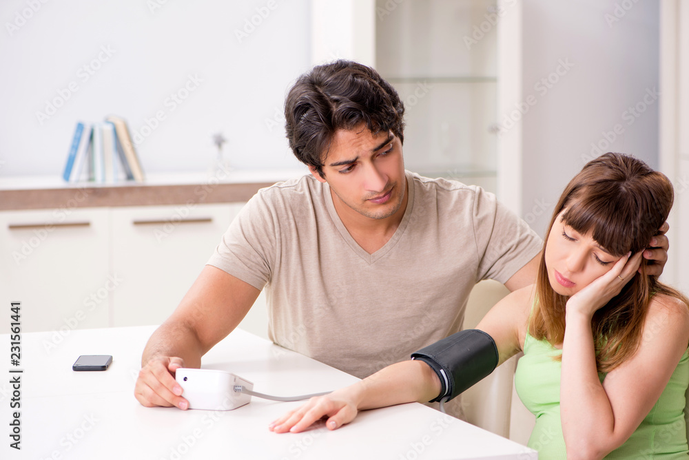Husband checking pregnant wife's blood pressure Husband checking pregnant wife's blood pressure