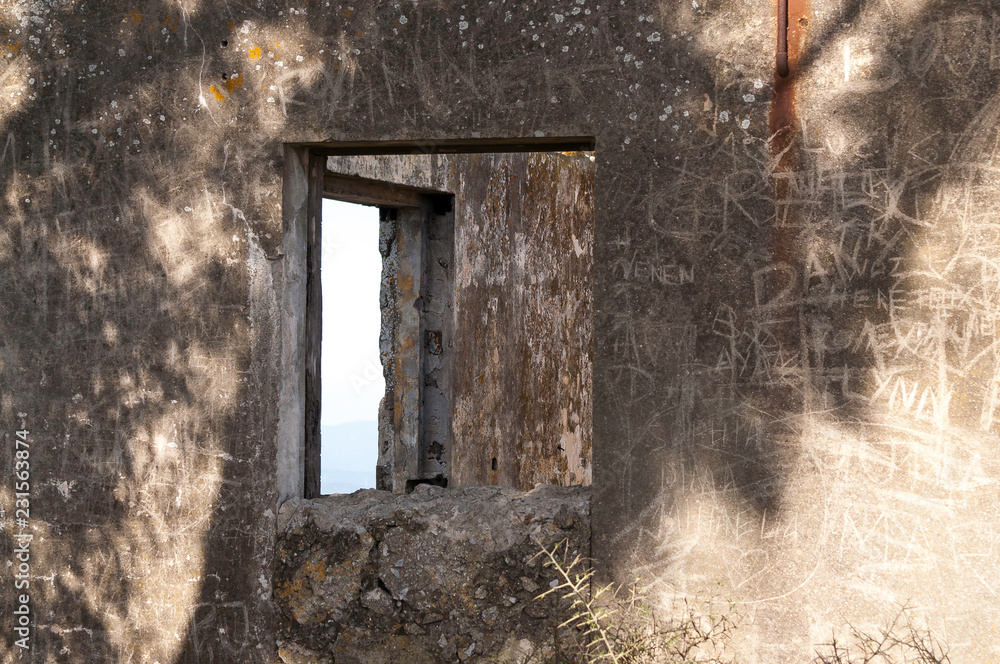 Sky through two glassless windows in an abandoned building with scrabbled walls. Sky through two glassless windows in an abandoned building with scrabbled walls.