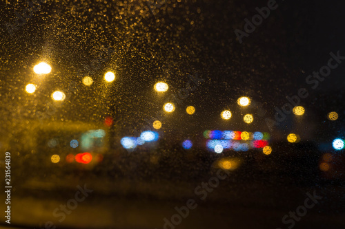 City lights behind glass with raindrops